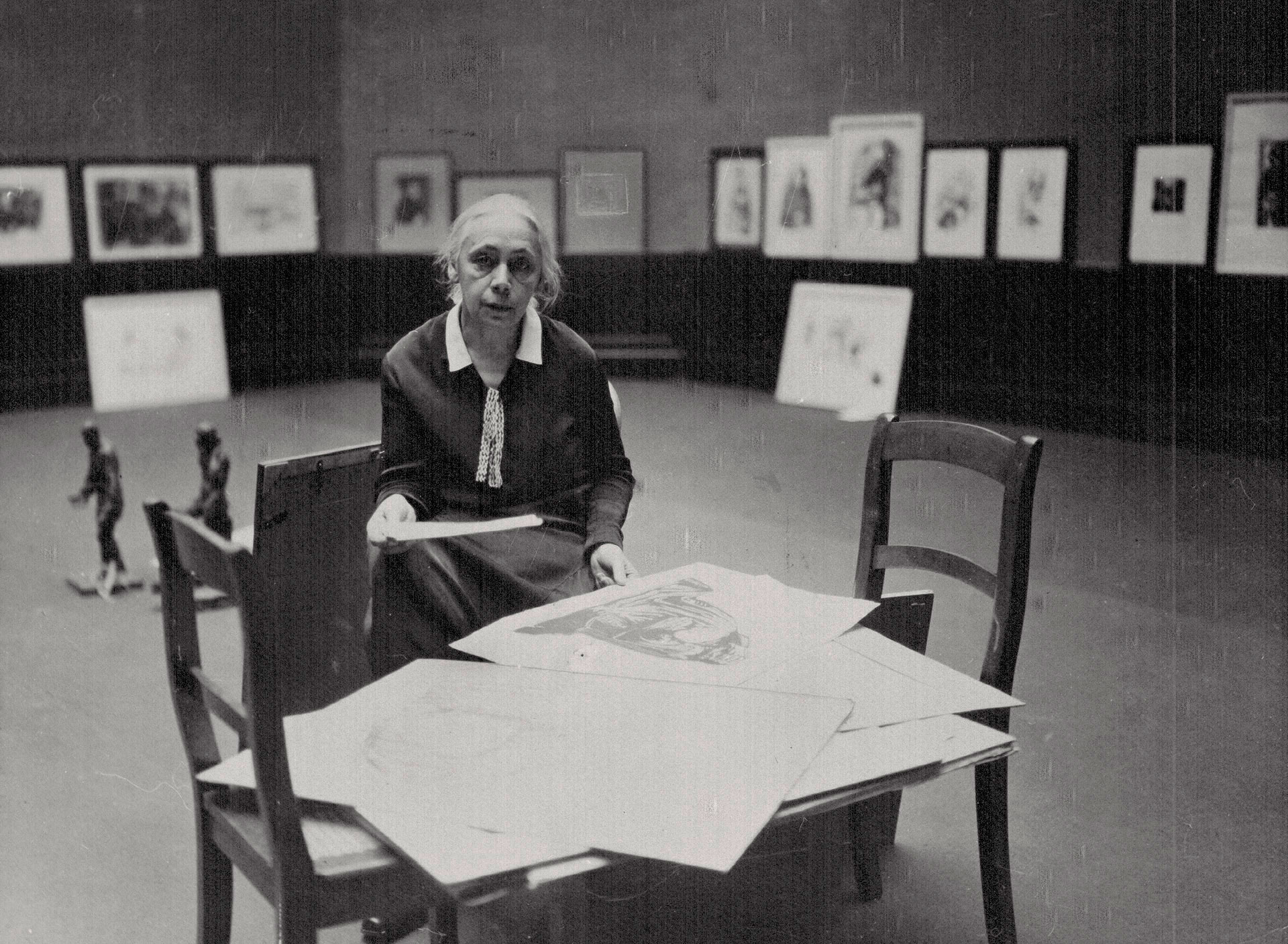  Käthe Kollwitz, 1927, choisissant les œuvres qu’elle exposera à l’Académie des arts de Prusse, photographe inconnu, succession Kollwitz © Käthe Kollwitz Museum Köln