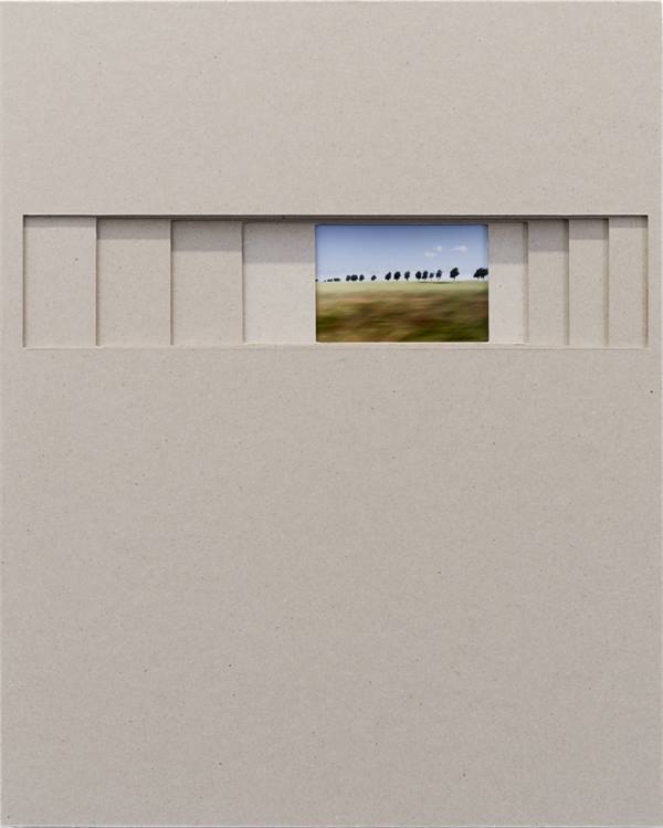 Dieses Kunstwerk besteht aus einer großen, minimalistischen Fläche aus graubraunem Karton, in deren oberem Drittel ein schmaler, horizontaler Schlitz eingeschnitten ist. Durch diese schieberartige Aussparung blickt man auf ein kleines, eingebettetes Farbf