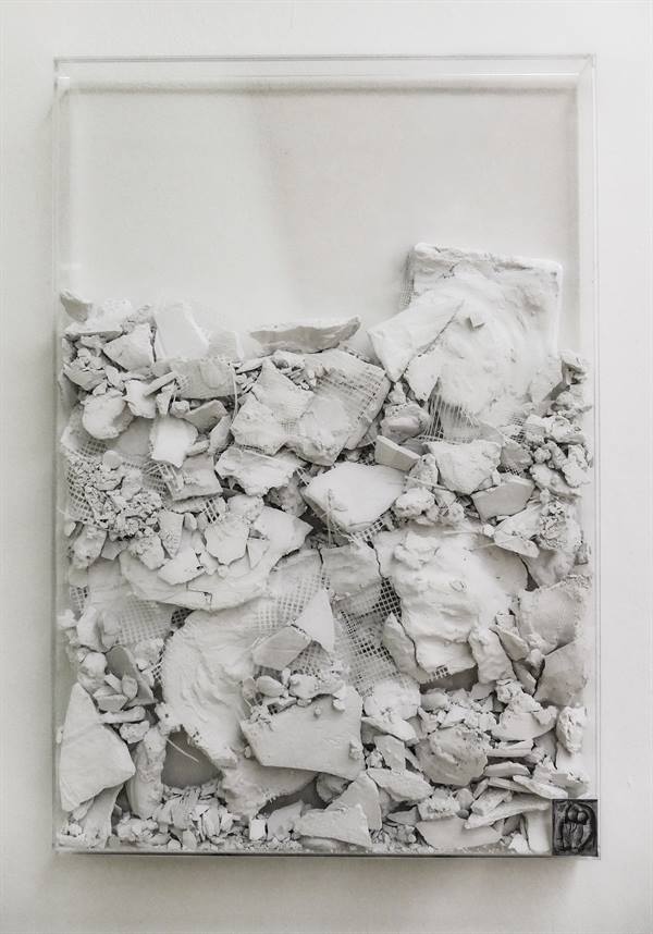 Das Bild zeigt das Kunstwerk - ein Wandobjekt - von Jana Ehls mit dem Titel "Was fehlt (VIII)" aus dem Jahr 2026. In einem Kasten aus Plexiglas, 60 x 88 x 5 cm, befinden sich Scherben aus Gips, offensichlich die Reste eines zerstörten Kunstwerkes.